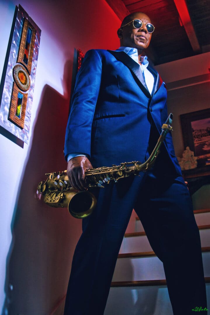 A man in a suit holding a saxophone.