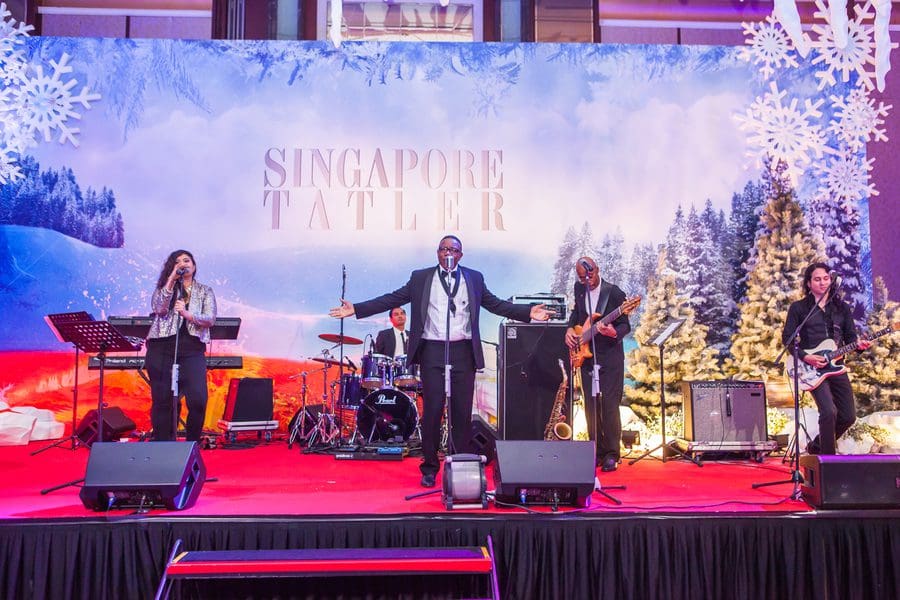 A group of people on stage at a christmas party in singapore.